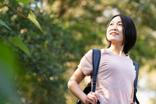 バックパックを背負って森の中にいる女性