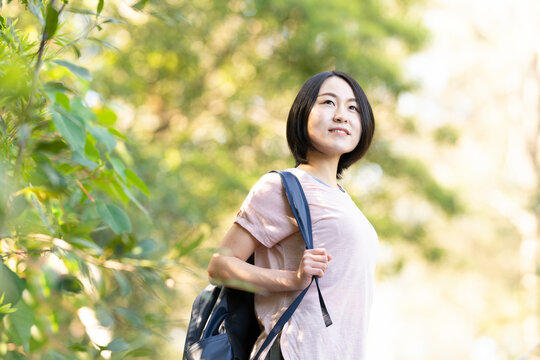 バックパックを背負って森の中にいる女性