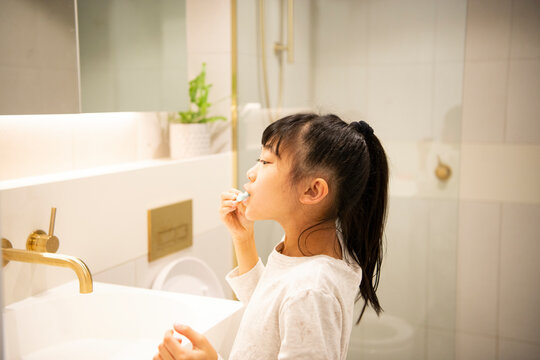 バスルームで歯を磨いている女の子