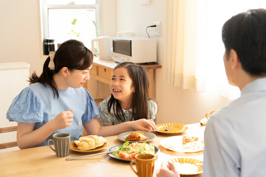 話をしながら朝食を食べている親子