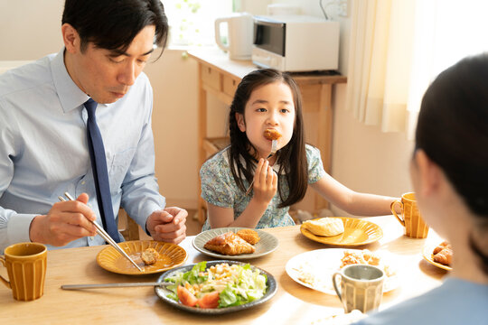 話をしながら朝食を食べている親子