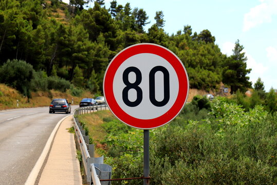 Road sign 80, speed limit, 80 on a mountain road. Speed limit sign on traffic background