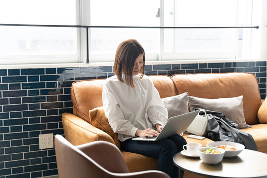 カフェでパソコンを開いて作業している女性