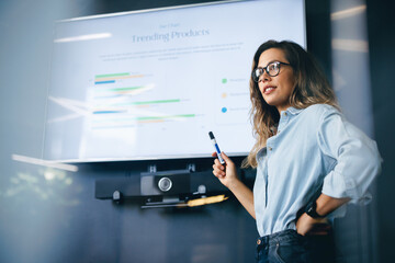Female team leader speaking on a trending products report in a business conference meeting