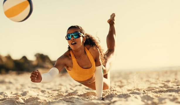 Young brazilian athlete spikes ball on beach volleyball court