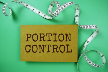Portion Control text on paper card with Measuring meter top view on green background, Healthcare...