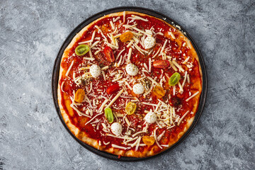 margherita pizza with cherry tomatoes before going in the oven