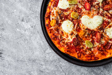 margherita pizza with cherry tomatoes and heart shaped cheese in the middle