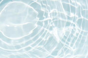 Blue water with ripples on the surface. Defocus blurred transparent blue colored clear calm water surface texture with splashes and bubbles. Water waves with shining pattern texture background.