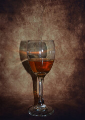 a glass of wine on a brown background
