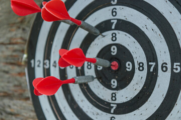Closeup view of darts with a darts stuck into the board. Wooden wall background. Traditional way to...