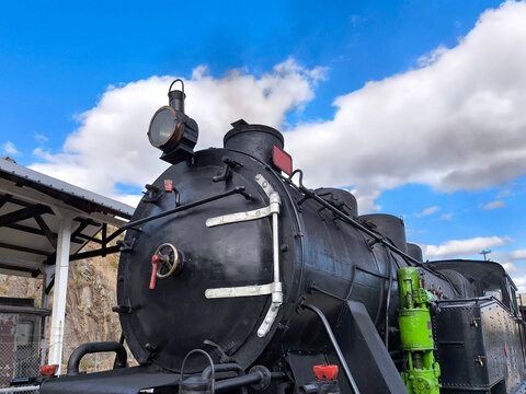 Uma elegante locomotiva a vapor e uma verdadeira rel&iacute;quia  vintage sob um c&eacute;u parcialmente azul