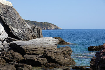 Panoramic view of a serene coastal landscape featuring calm blue waters and distant hills under a clear sky. Peaceful and tranquil scene perfect for relaxation and travel concepts.