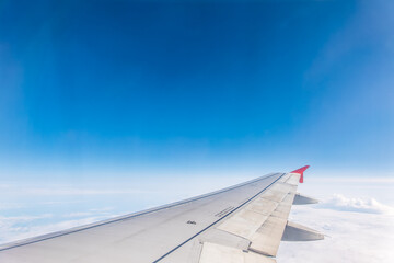 Obraz premium View from the airplane window at a beautiful cloudy sky and the airplane wing