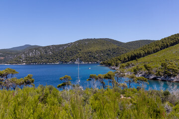 Panoramic view of a serene coastal landscape featuring calm blue waters and distant hills under a clear sky. Peaceful and tranquil scene perfect for relaxation and travel concepts.