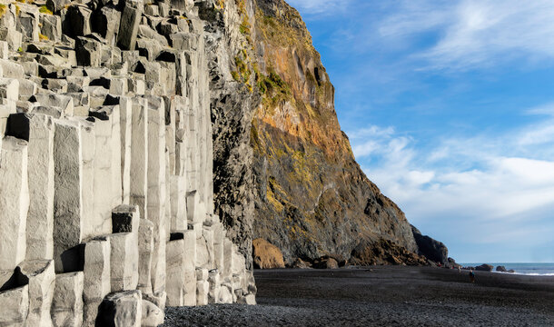 Gardar basalt columns on Reynisfjara Black Sand Beach, Iceland. A rocky cliff with a gray and white rock formation