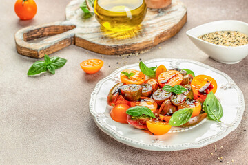 Ripe fresh colorful tomatoes salad with olive oil and basil leaves. clean eating for weight loss. copy space, top view