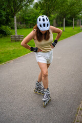 Roller skater woman in park rollerblading on inline skates. Outdoor activities. Summer roller skating. © dtatiana