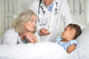 Fototapeta premium Little girl in the hospital with her grandmother and doctor