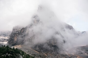 Landscapes of epic mountains during the sunset surrounded by clouds, with warm and cold lights. huge cliffs and epic views from the wild nature. 