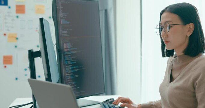 Young adult Asia female freelance eyeglasses typing write prompt AI bot IT app smart program nomad, video game, terminal with coding, user interface, designer, big data center on desktop computer.