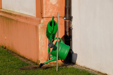 Stand with two green plastic watering cans at the cemetery of the town of Puch in Bavaria © were
