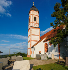 church of saint Sebastien under a blue sky with village cemetery and the thousand-year-old ediga lime tree in germany, Puch, 20.7.2024 © were