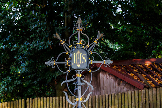 Wrought-iron cemetery cross with the Christian abbreviation of the name of Jesus Christ JHS in a cemetery, Germany, Puch, 20.7.20245