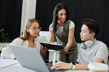 Three people work together on a project in a modern office.