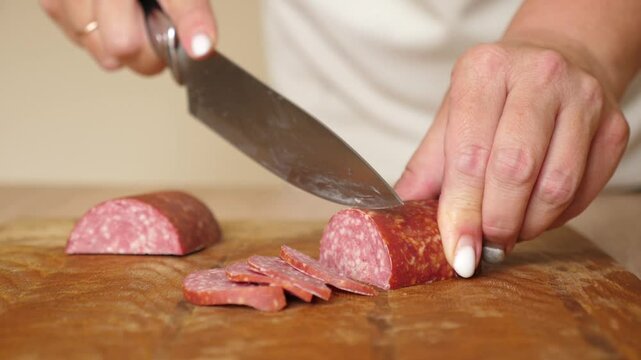 Cut salami for cooking. Cooking homemade meals.