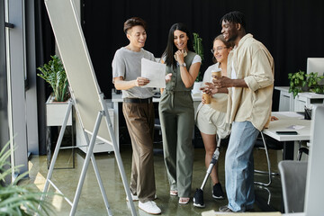 A group of colleagues collaborates on a project, reviewing documents and brainstorming.