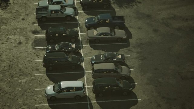 A bustling parking lot filled with a multitude of cars parked in neat rows.