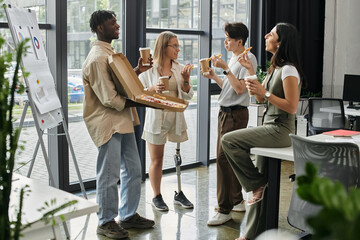 A team of four enjoys a break with pizza and coffee in a modern office.