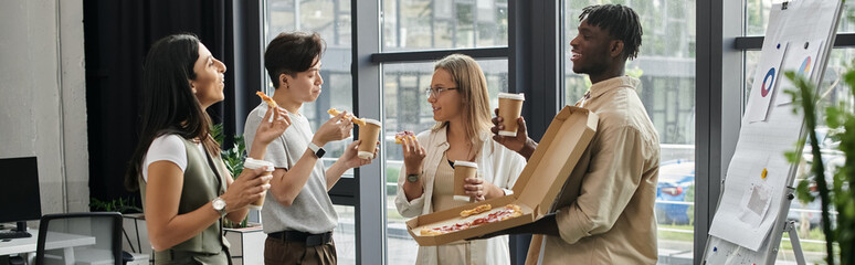 Four colleagues take a break from work to eat pizza and drinks