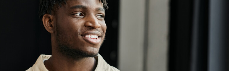 Obraz premium A young man, a member of a startup team, looks optimistically toward the future.