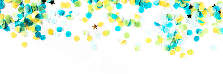 Happy birthday or any holiday festive background with confetti and copy space, a panorama. Carnival greeting card with golden stars, on a white background