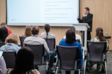 Fototapeta premium Business professional giving presentation to attentive audience in modern conference room