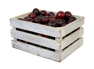 Many cherry plums in wooden crate isolated on white background
