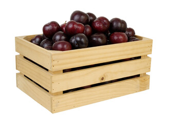 Many cherry plums in wooden crate isolated on white background
