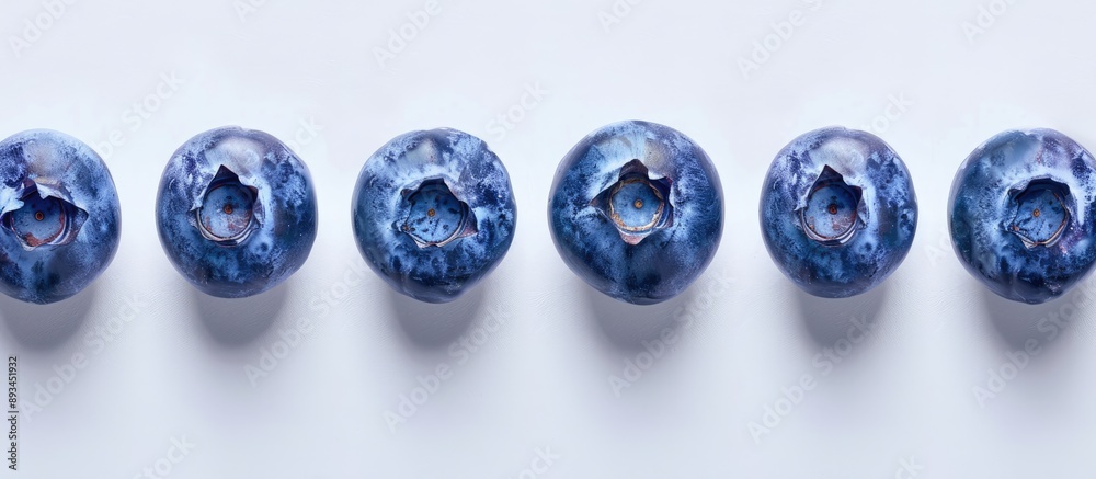 Poster blueberries arranged in a neat row on a white backdrop with ample copy space image