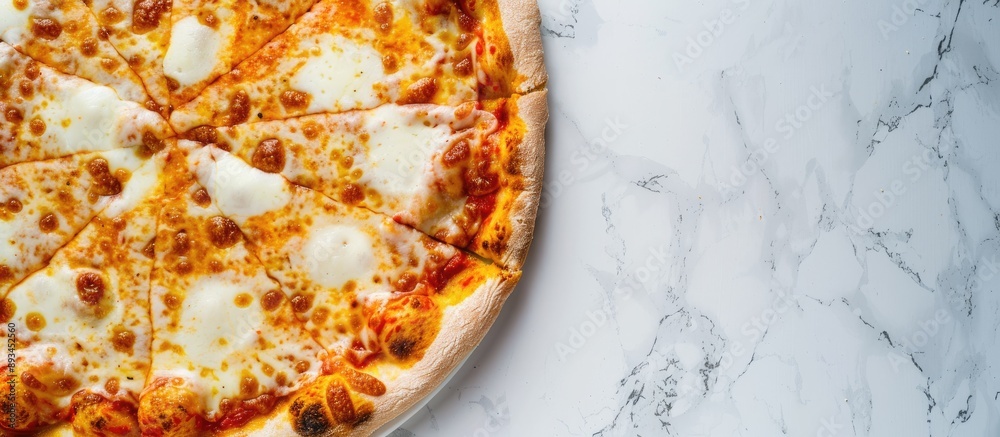 Leinwandbilder Top view of a traditional Italian pizza topped with cheese set on a white marble surface with room for text or images in the frame. with copy space image. Place for adding text or design