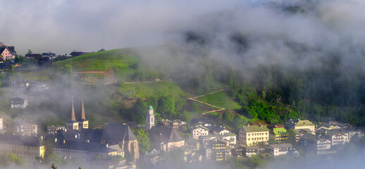 Fototapeta premium Morgennebel über der im Tal liegenden Ortschaft Berchtesgaden, Bayern, Deutschland