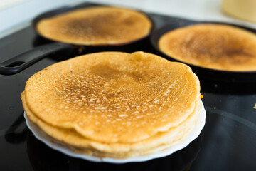 Cooking traditional pancakes from wheat flour in the kitchen