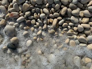 A rocky beach with a foamy ocean