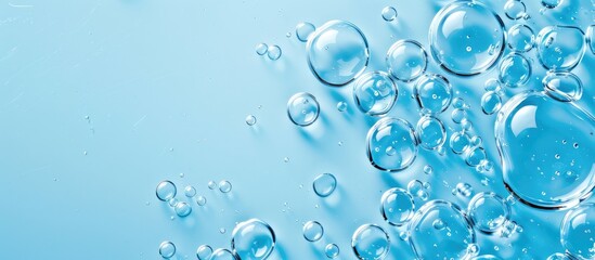 Transparent gel droplet with bubbles on blue backdrop, with copy space image available.