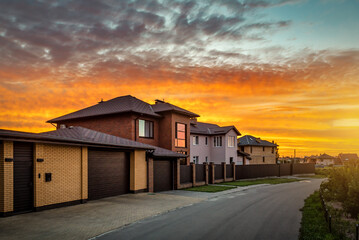 Suburb area with houses asphalt road and red sunset
