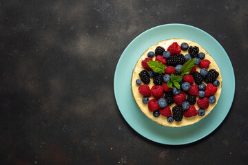 Homemade cake with fresh berries on dark background.