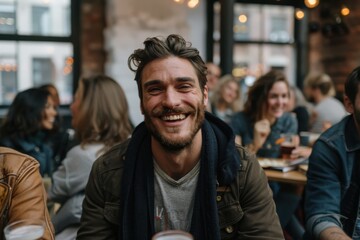 Obraz premium A group of people is pictured in a cozy cafe environment, engaged in conversation and having drinks, creating a vibrant, social atmosphere around a wooden table.