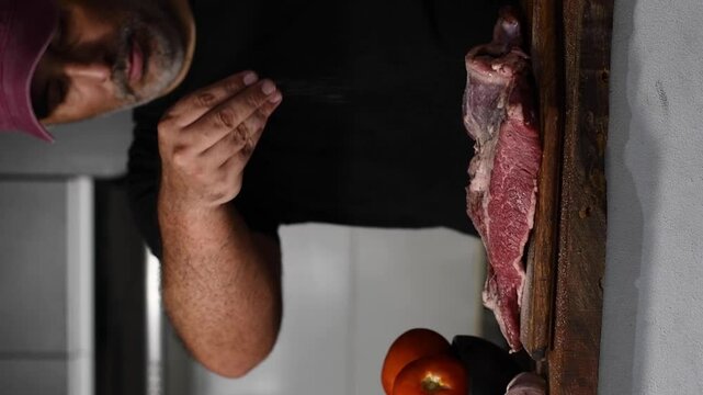 Hombre pone sal a la carne. Carne cruda.  condimentar comida. 