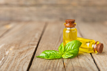 Basil essential oil on a textured wooden background. Basil essential oil and fresh leaves. Aromatherapy. Aroma oil. Medical herbs. Alternative medicine. Place for text. Copy space.